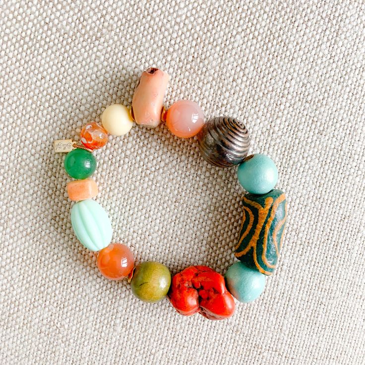 Salty breezes and hints of bright colors. Features red coral, rosewood prayer beads, honey jade, green jade. Prayer beads symbolize love, good fortune, long life. Sterling silver BelleStyle Logo tag. Measures 7-8”, regular size. Comes in linen travel pouch. One of a kind. Made in USA. Spiritual Wooden Beads Stretch Bracelet For Healing, Multicolor Jade Spiritual Bracelets, Spiritual Multicolor Jade Bracelets, Adjustable Multicolor Jade Beaded Bracelets, Multicolor Artisan Bracelets For Meditation, Good Luck Adjustable Beaded Bracelets With Natural Stones, Bohemian Wooden Beads Stretch Bracelet For Meditation, Spiritual Stretch Bracelet With Large Beads For Beach, Multicolor Jade Beaded Bracelets