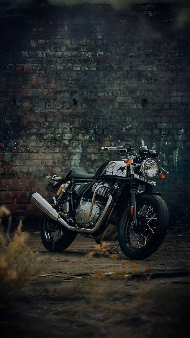 a motorcycle parked in front of a brick wall