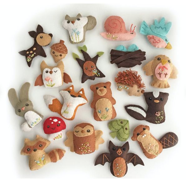 many different types of felt animals on a white surface