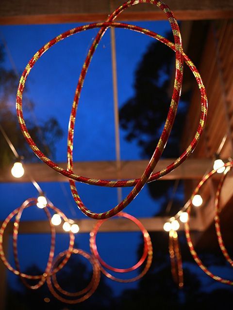 some lights that are hanging from the ceiling in front of a window at night time