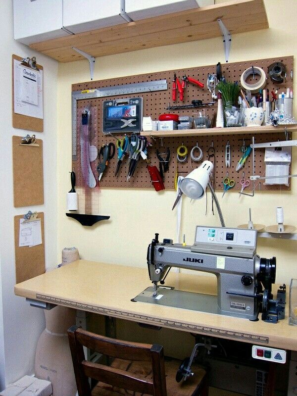 a sewing machine sitting on top of a table next to a shelf filled with scissors