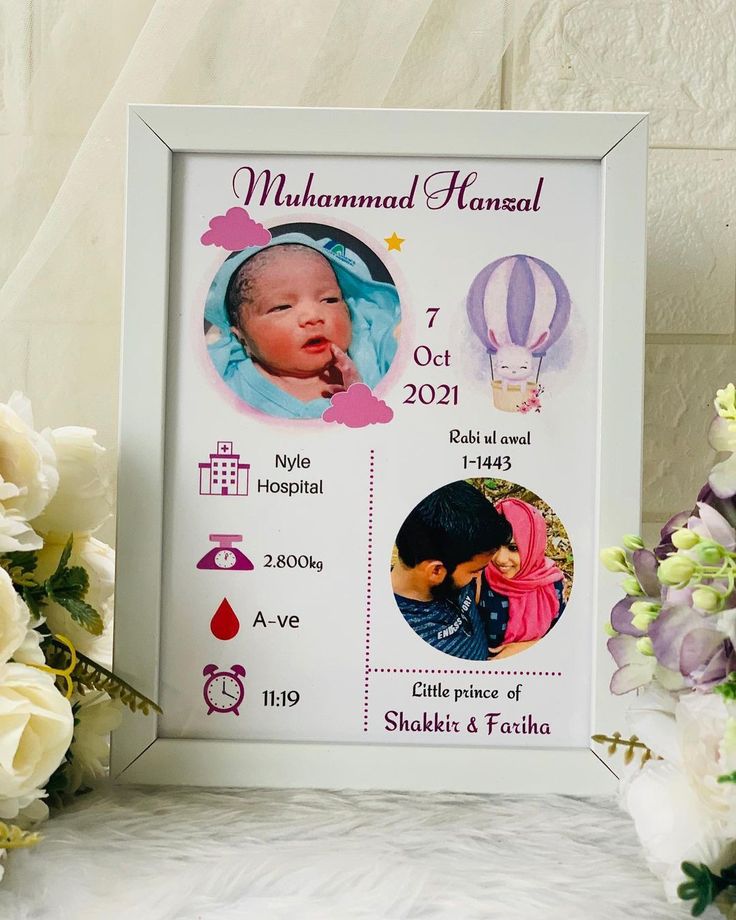 a baby's birth announcement is displayed next to flowers and a vase with white roses