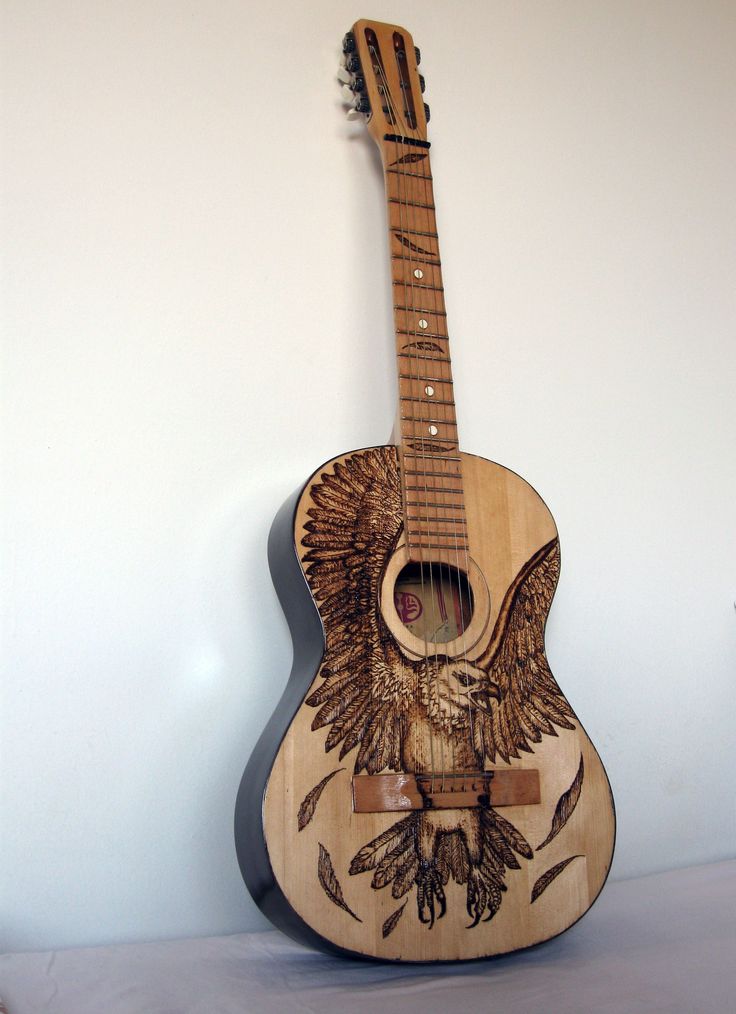 a wooden guitar with an eagle design on it