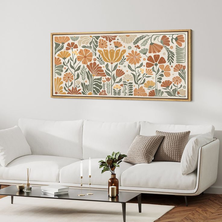 a living room with a white couch, coffee table and large painting on the wall