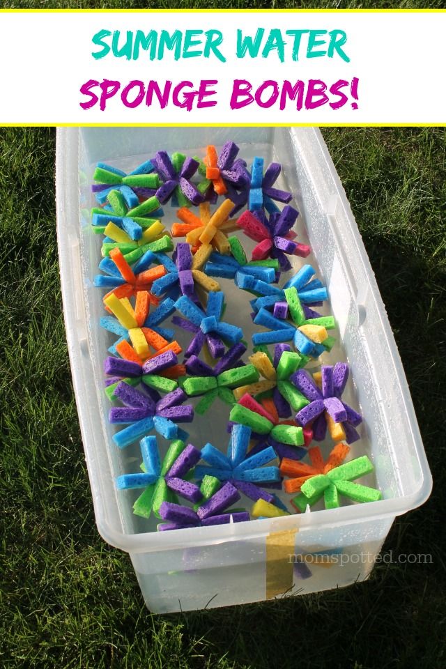 a plastic container filled with colorful sprinkles sitting on top of green grass