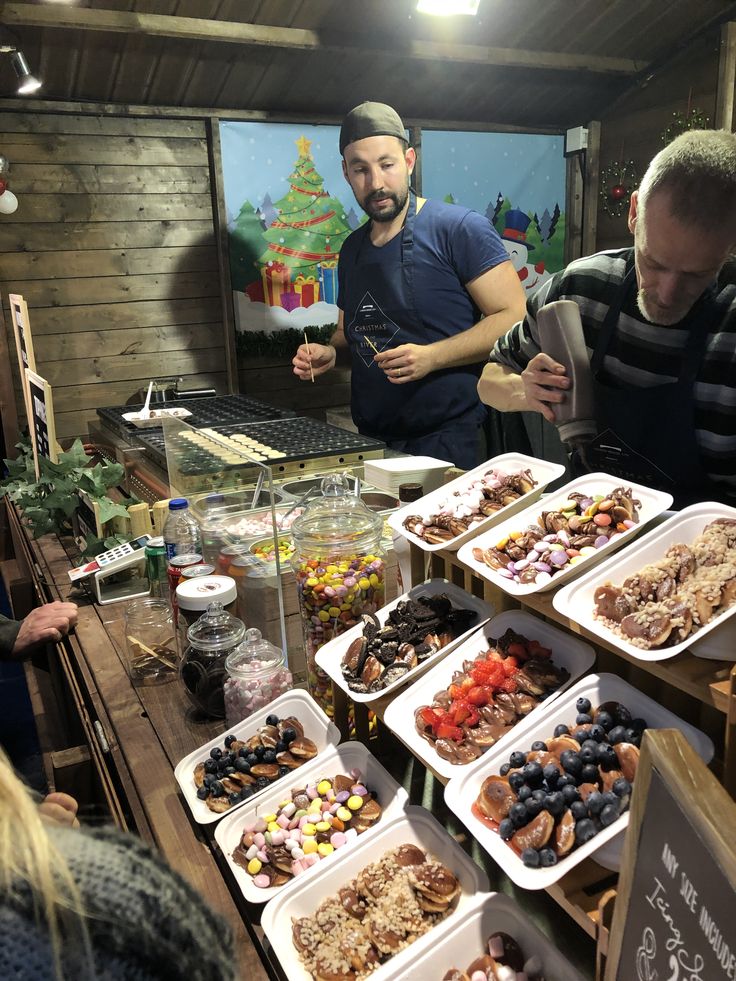 people standing around a table filled with food