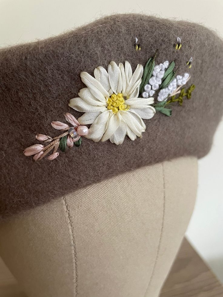 a close up of a hat on a mannequin's head with flowers