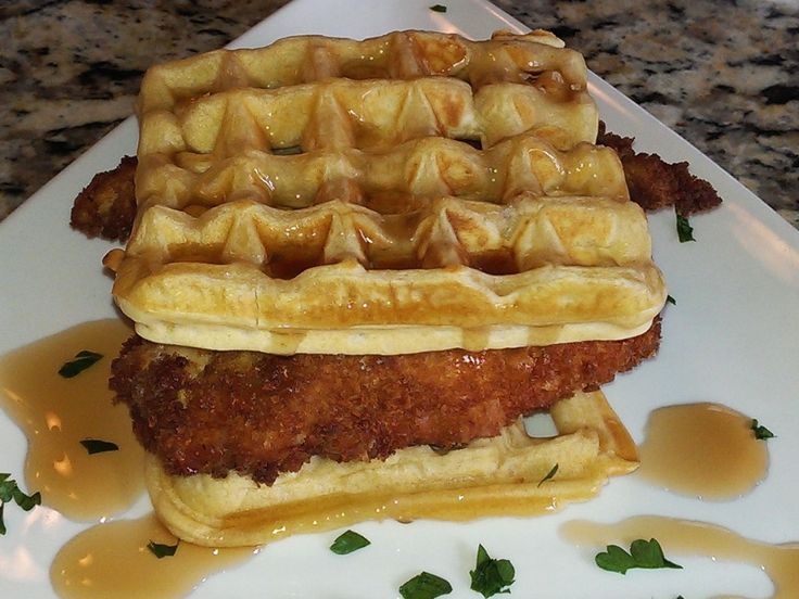 fried chicken and waffles on a plate with syrup drizzled over them