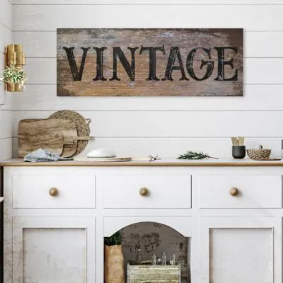 an old wooden sign that says vintage on the side of a white painted cabinet in a kitchen