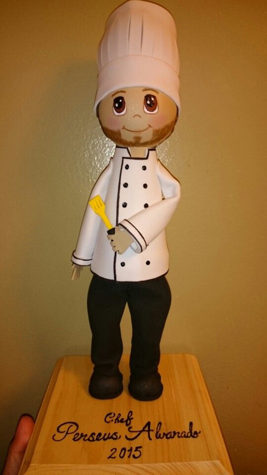 a cake shaped like a chef standing on top of a wooden block with writing on it