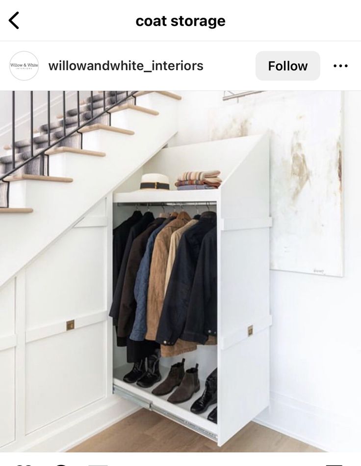 an open closet under the stairs with clothes hanging in it and shoes on top of them