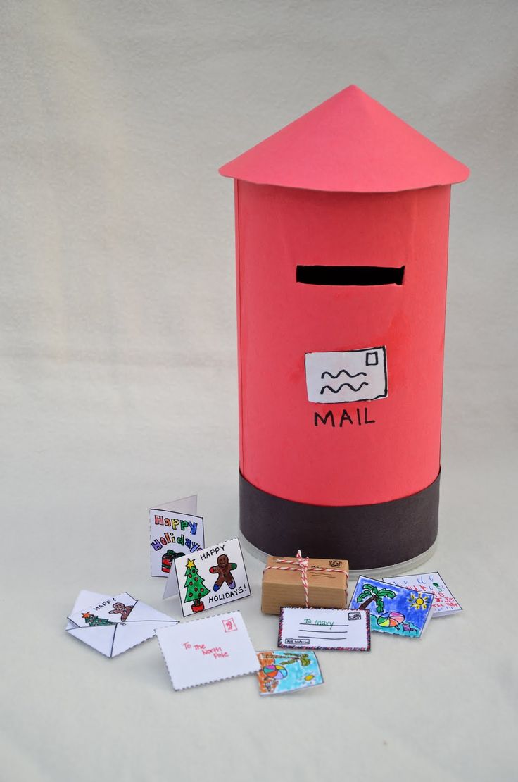 a red mailbox sitting on top of a table next to cards and magnets