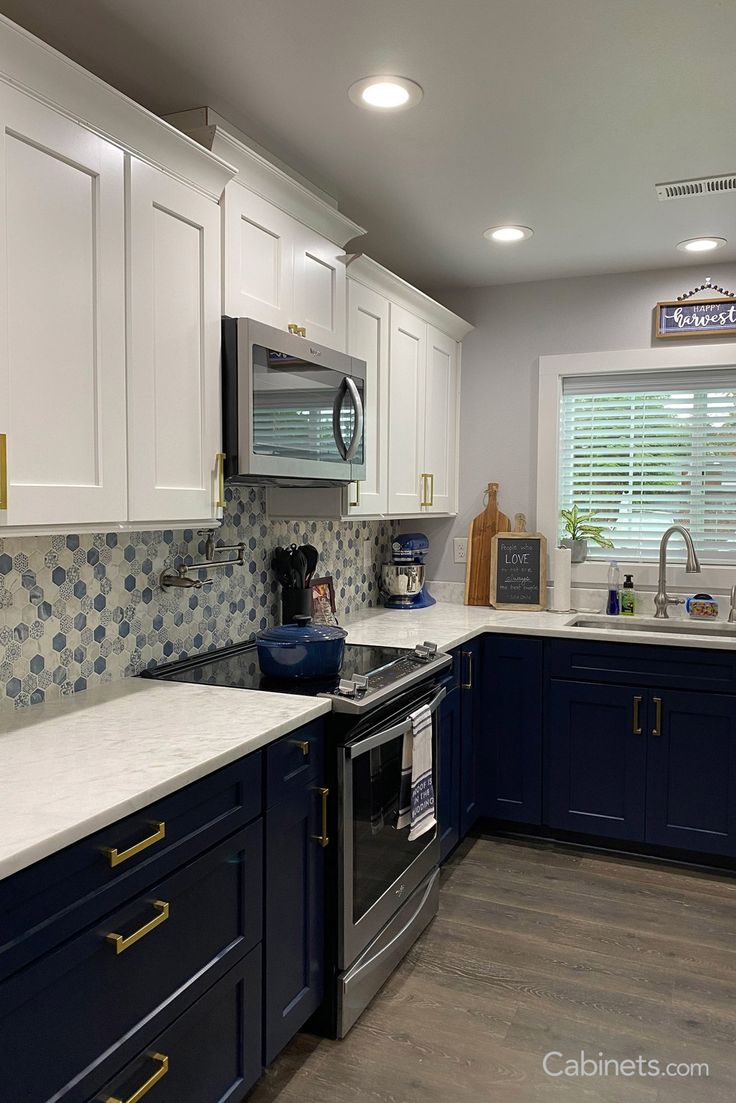 a kitchen with blue cabinets and white counter tops is seen in this image from the front view