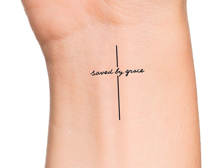 a woman's wrist with a small tattoo that reads, saved by youe