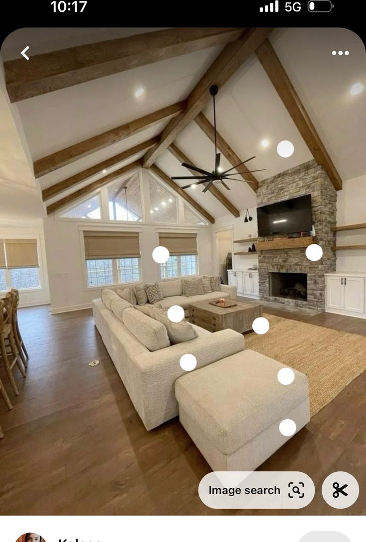 a large living room with couches and a ceiling fan in it's center