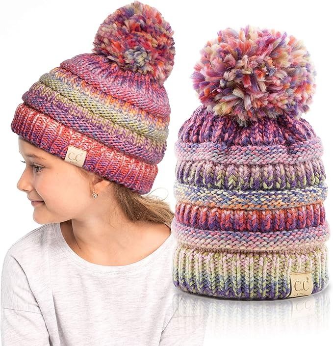 a girl wearing a multicolored knit hat with pom - pom on top