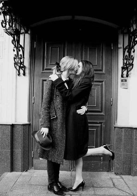 two people are kissing in front of a door