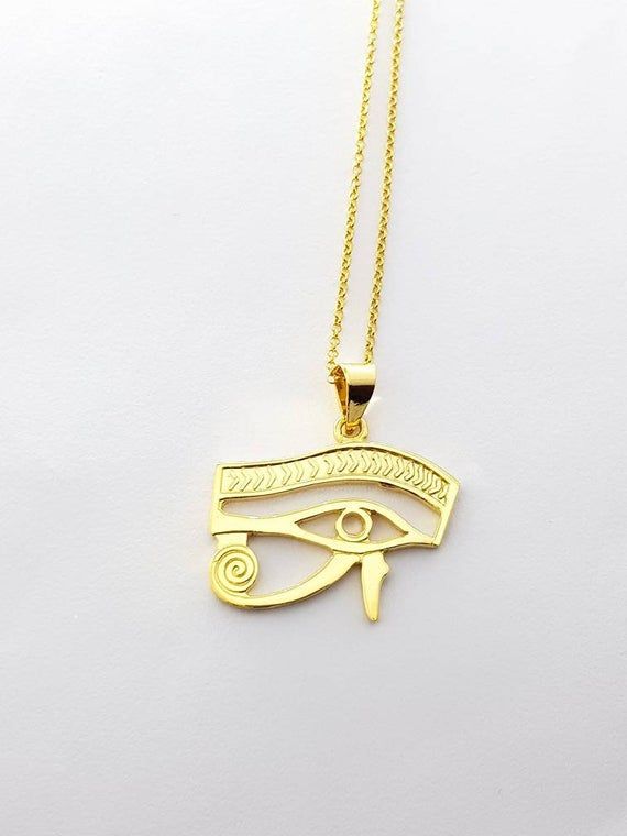 Eye of Horus Gold Necklace, 14k Gold Vermeil Over Sterling Silver Eye Necklace, Egyptian Jewelry.Eye of Horus, in ancient Egypt, a symbol representing protection, health, and restoration.According to Egyptian myth, Horus lost his left eye in a struggle with Seth. The eye was magically restored by Hathor, and this restoration came to symbolize the process of making whole and healing. For this reason, the symbol was often used in amulets.• Material: Eye Of Horus necklace is handcrafted using premi Symbolic 14k Gold Necklaces, Symbolic 14k Gold Necklace, Ancient Gold Pendant Jewelry, Ancient Style Gold Pendant Jewelry, Gold Pendant Jewelry In Vintage Style, Gold Antique Pendant Jewelry, Symbolic 14k Stamped Pendant Necklace, Gold Ancient Style Engraved Necklace, Ancient Style Gold Engraved Necklace