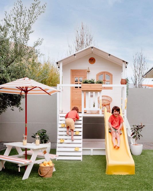 two children playing on a slide in the backyard