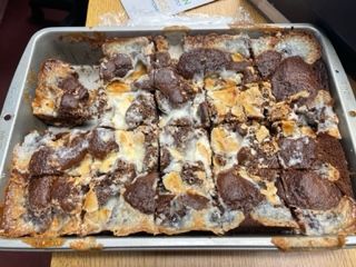 a pan filled with lots of brownies on top of a wooden table