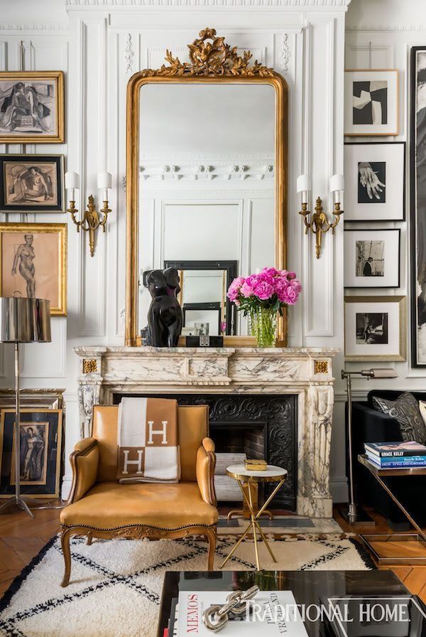 a living room filled with furniture and pictures on the wall next to a fire place