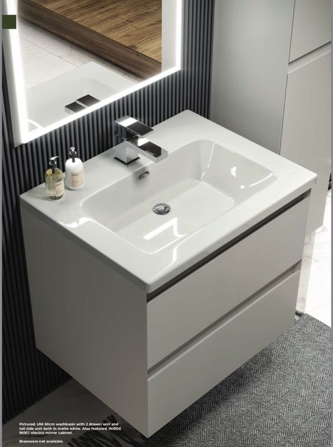 a white sink sitting under a mirror in a bathroom next to a wall mounted faucet