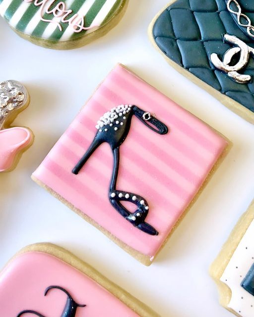 decorated cookies are arranged on a table with pink, blue and white icing in the shape of purses