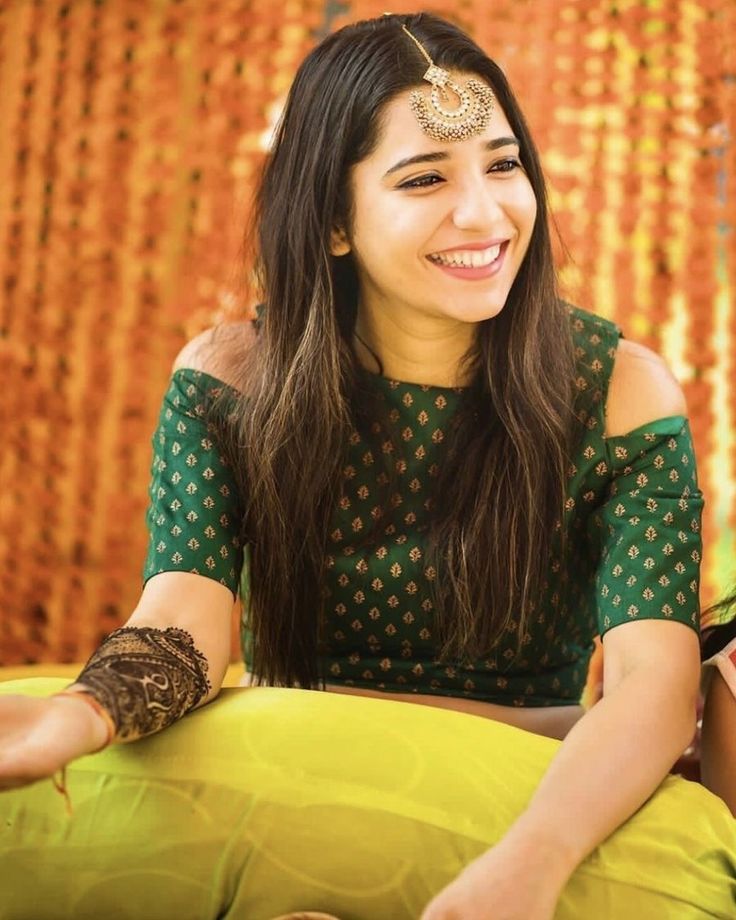 a woman sitting on top of a yellow pillow