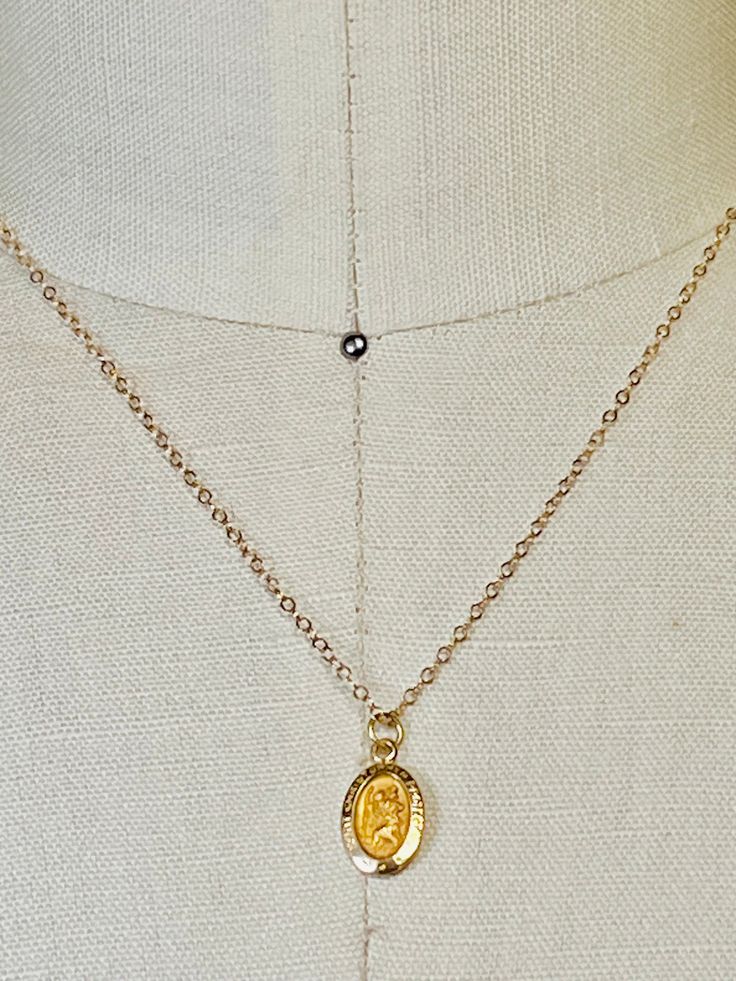 14k solid yellow gold St. Christopher small oval medallion pendant. 14mm (includes measurement of attached ring x 8mm wide. Displayed from a 14k solid gold 16 inch cable  1.5mm chain. Even though this is a smaller delicate chain it's substantial enough to wear alone without the pendant. Total gold weight 1.4 grams. This a smaller pendant that I paired with a 16 inch necklace. If you would like a longer necklace or heavier necklace I have several available in my shop. I can add your pendant to any necklace of your choosing. Message me for prices, length and styles. Please email me if you any questions about this listing or any of my other listings. I will get back to you with-in the day. It helps to take a ruler and use the measurements as a comparison. Item's pictures are enlarged and zoom Gold Oval Charm Necklace With Adjustable Chain, Gold Oval Jewelry With Adjustable Chain, Gold Oval Pendant Charm Necklace For Anniversary, Gold Engraved Oval Cabochon Necklace, Gold Oval Pendant Charm Necklace Engraved, Oval Charms Jewelry For Memorial, Gold Oval Charm Necklaces, Gold Oval Charm Necklace, Gold Oval Pendant Jewelry With Charms