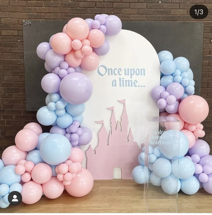 there are balloons on the table with a sign