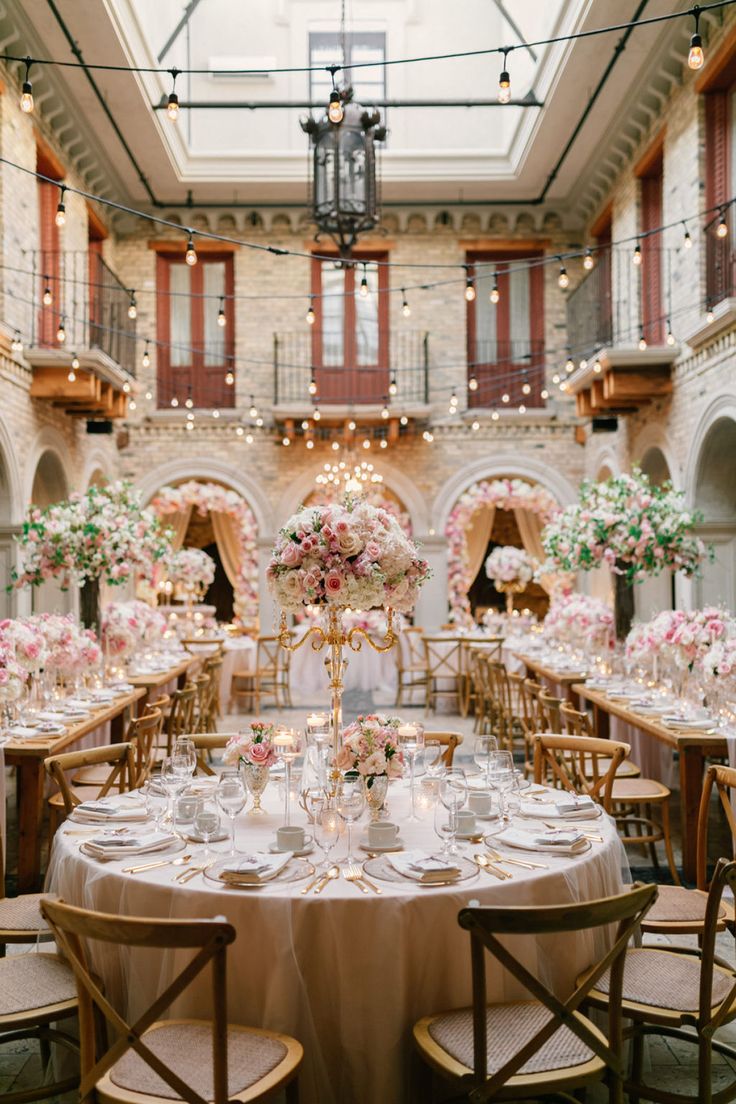 the tables are set with white and pink flowers