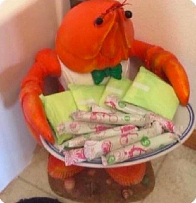 an orange stuffed animal sitting on top of a blue and white bowl filled with candy