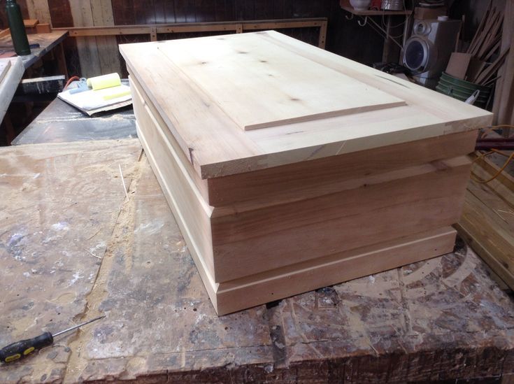 a large wooden box sitting on top of a piece of plywood in a workshop