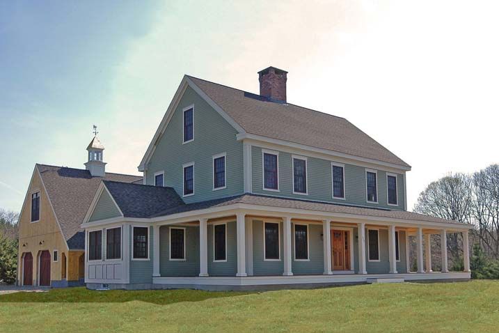 a large blue house sitting on top of a lush green field