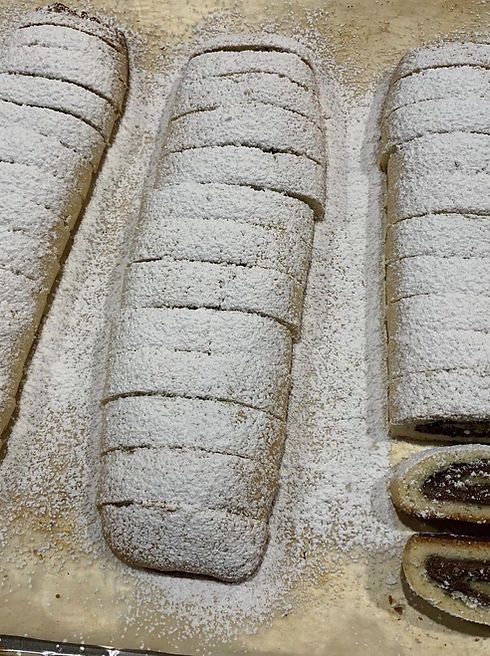 three loaves of bread sitting on top of a baking pan covered in powdered sugar