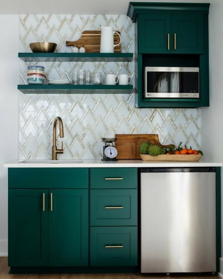 a kitchen with green cabinets and white tile backsplashing, stainless steel dishwasher