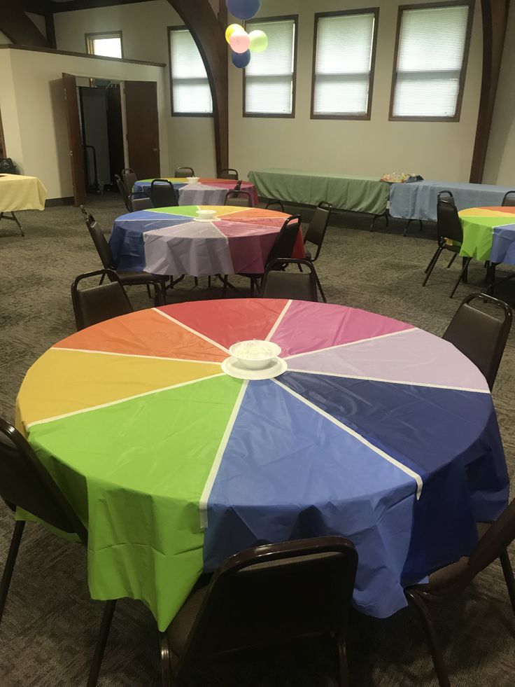 an empty banquet room with tables covered in colorful tablecloths