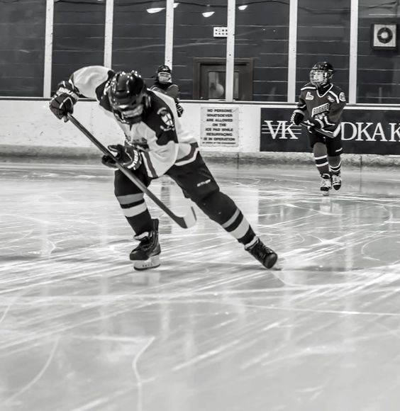 two men playing ice hockey on an indoor rink