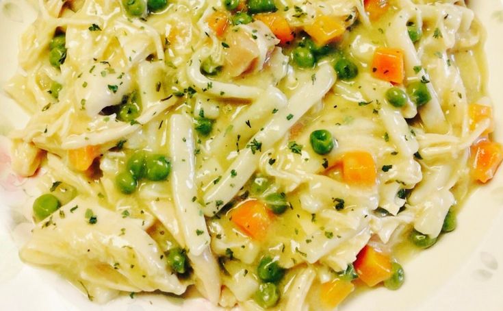 a white plate topped with pasta and peas