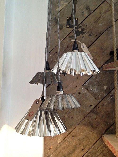 three metal lamps hanging from a wooden ceiling