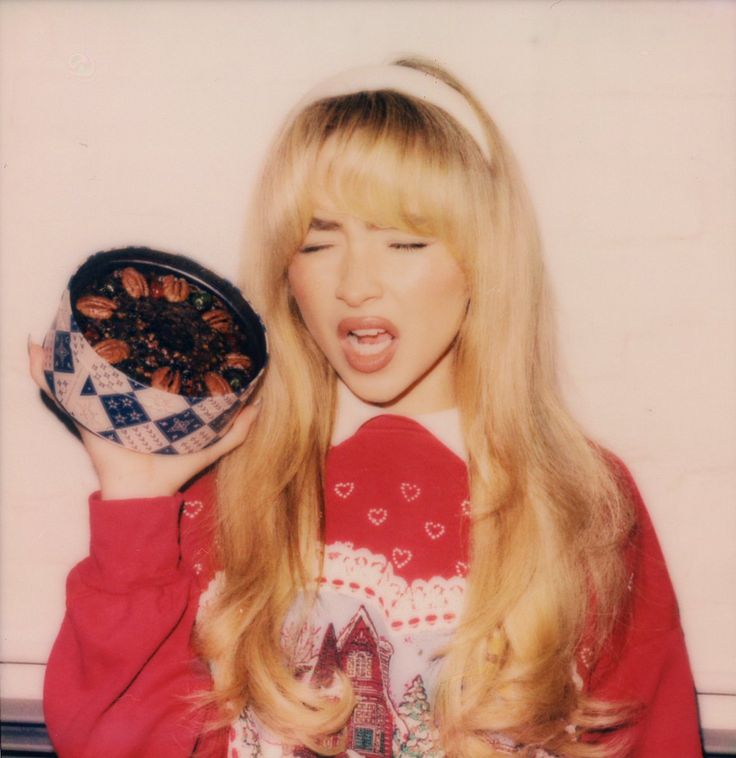 a woman with long blonde hair holding a bowl of cereal in front of her face