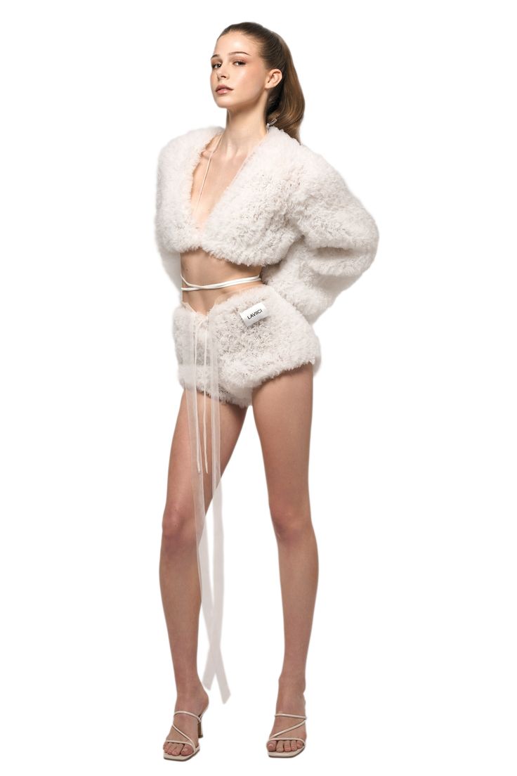 a woman in white fur coat and shorts