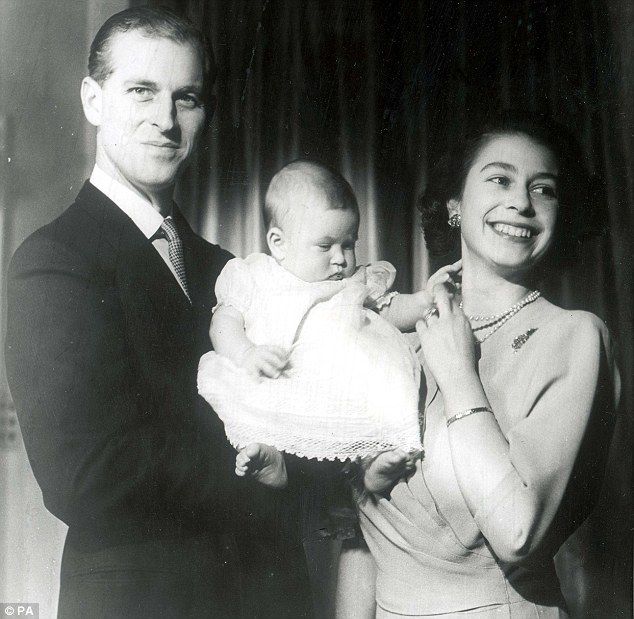 an old black and white photo of a man holding a baby in his arms while standing next to two women