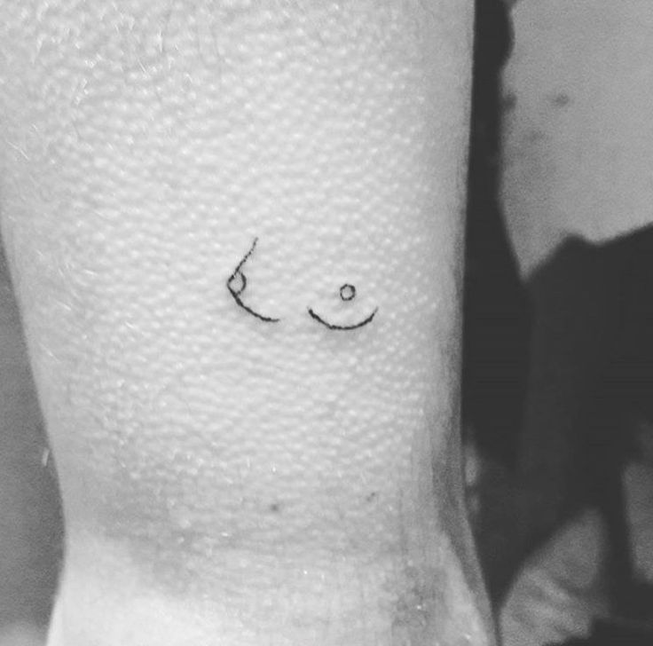 a black and white photo of a person's arm with a smiley face on it