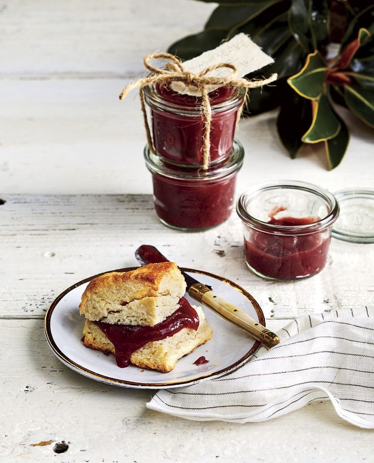 two jam sandwiches on a plate next to jars of jelly