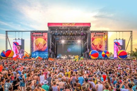 a large group of people standing in front of a stage with giant balls on it