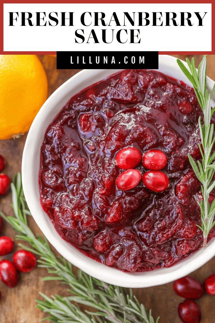 cranberry sauce in a white bowl with rosemary sprigs and oranges