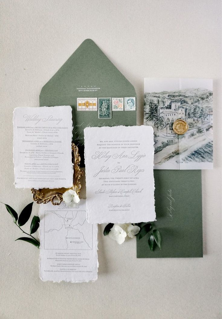 the wedding stationery is laid out on top of each other, including two envelopes