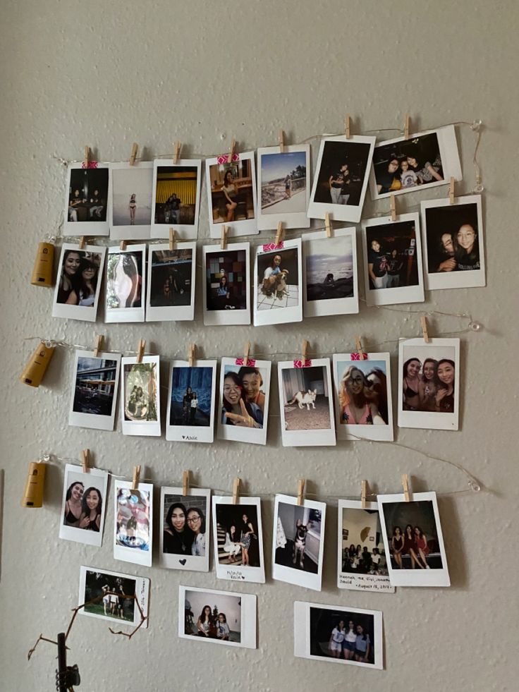 several pictures hanging on a wall with clothes pins attached to them and photos pinned to the wall