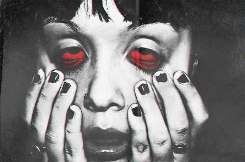 a woman with red eyes and nails covering her face